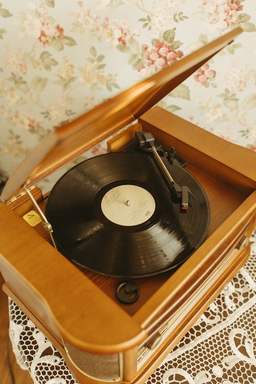 Modern turntable playing a colorful vinyl record with a cozy background.